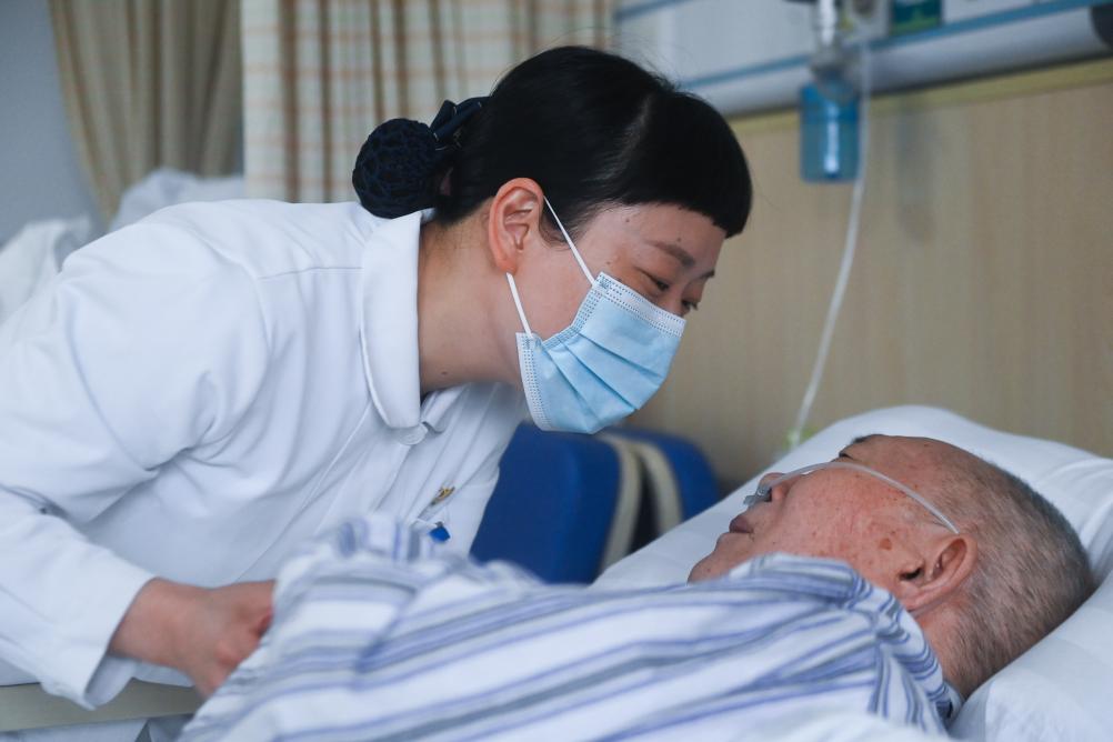2023年5月11日,浙江医院医疗照护病房护士长项巧珍在病房内与卧床的
