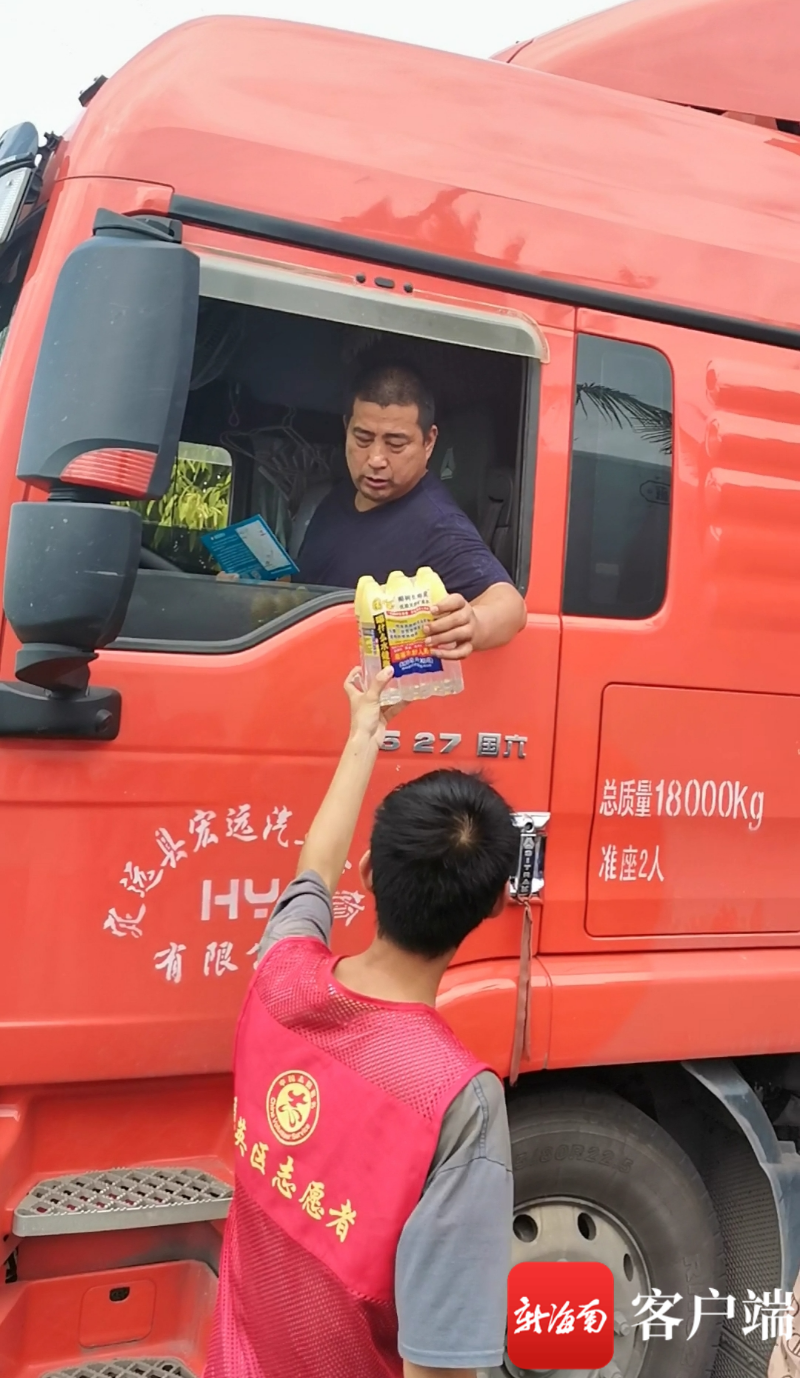 志愿者走进待渡货车停车区域逐个提供送水服务。记者 王康景 摄