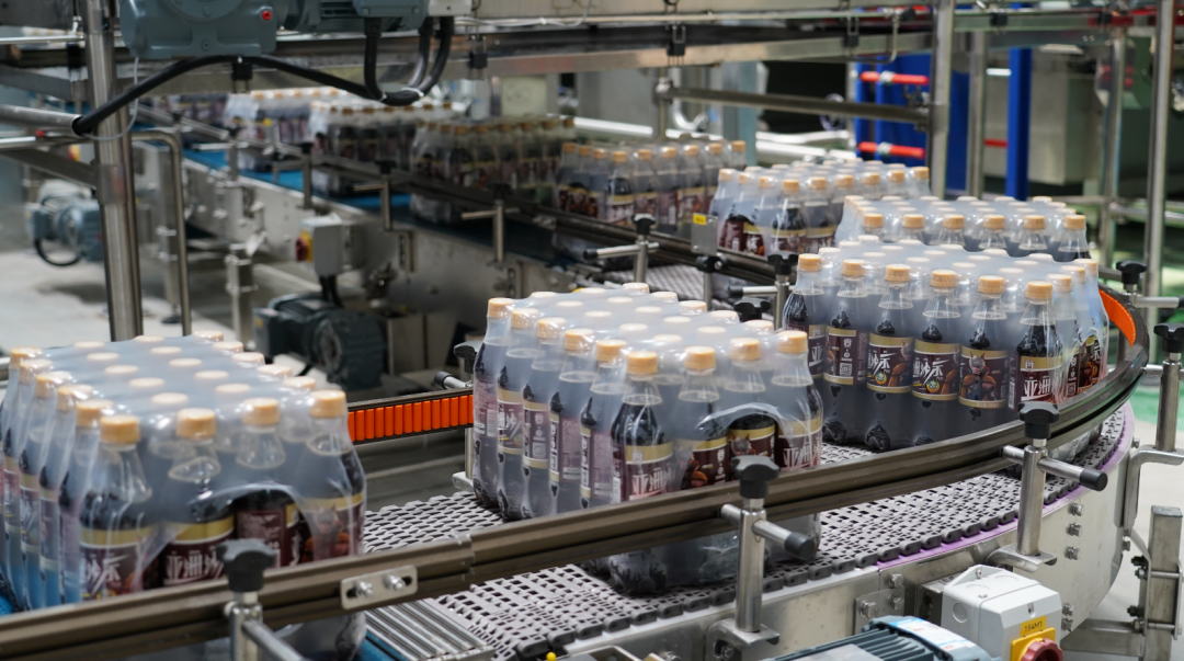 亚洲汽水全新综合工厂首期项目正式投产,生产线上一箱箱"沙示"正在