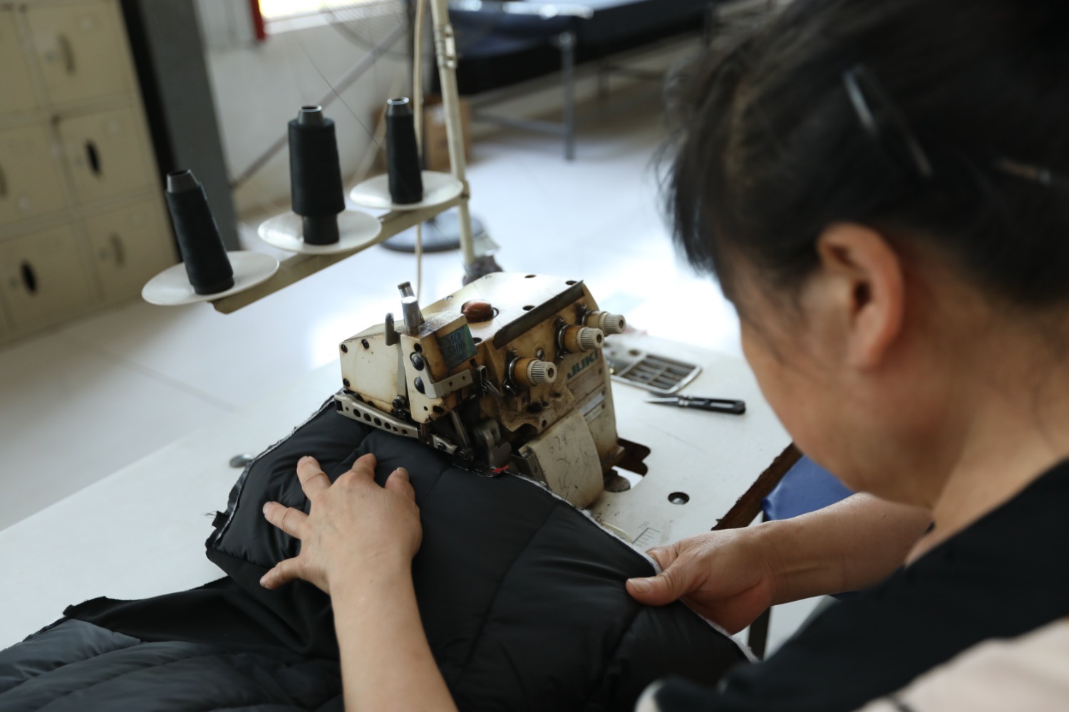 图为在河北省香河县瑞康衣业有限公司车间,工人使用自动裁床对布料