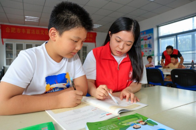 志愿者正在辅导孩子们暑假作业.通讯员 赵明 摄