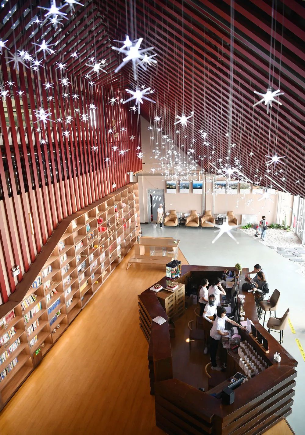 7月20日,工作人员在沙漠图书馆大厅给游客办理借书.