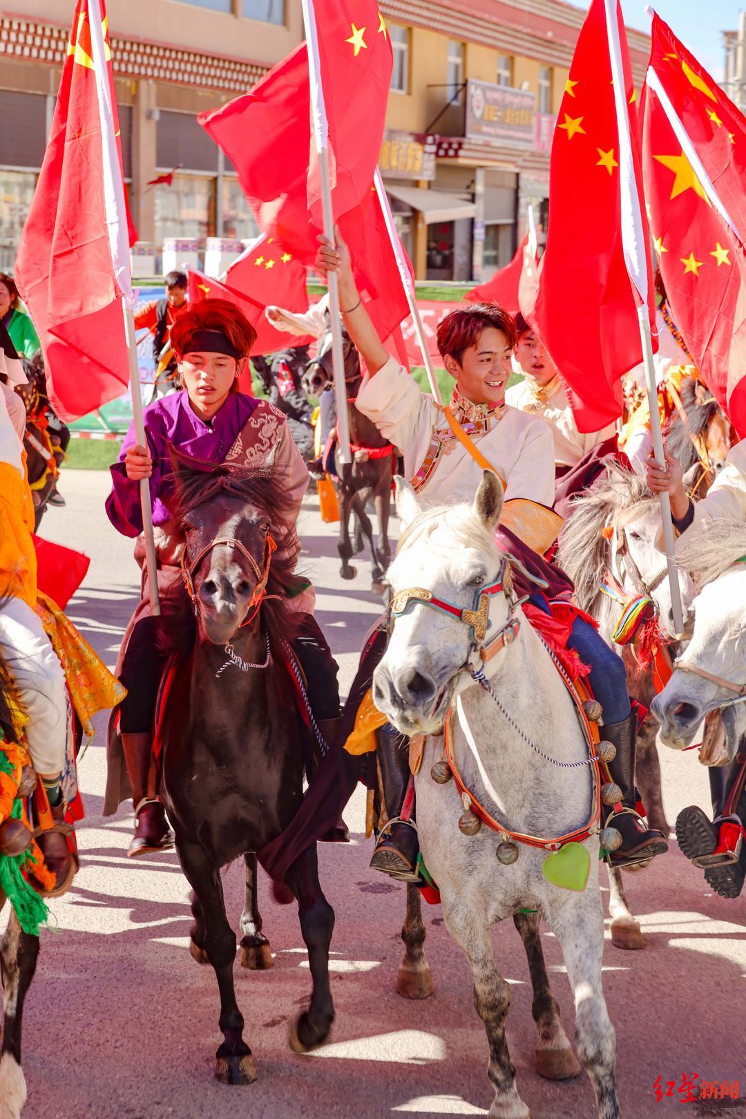 丁真珍珠盛装打扮手持国旗领队,参与巡游活动