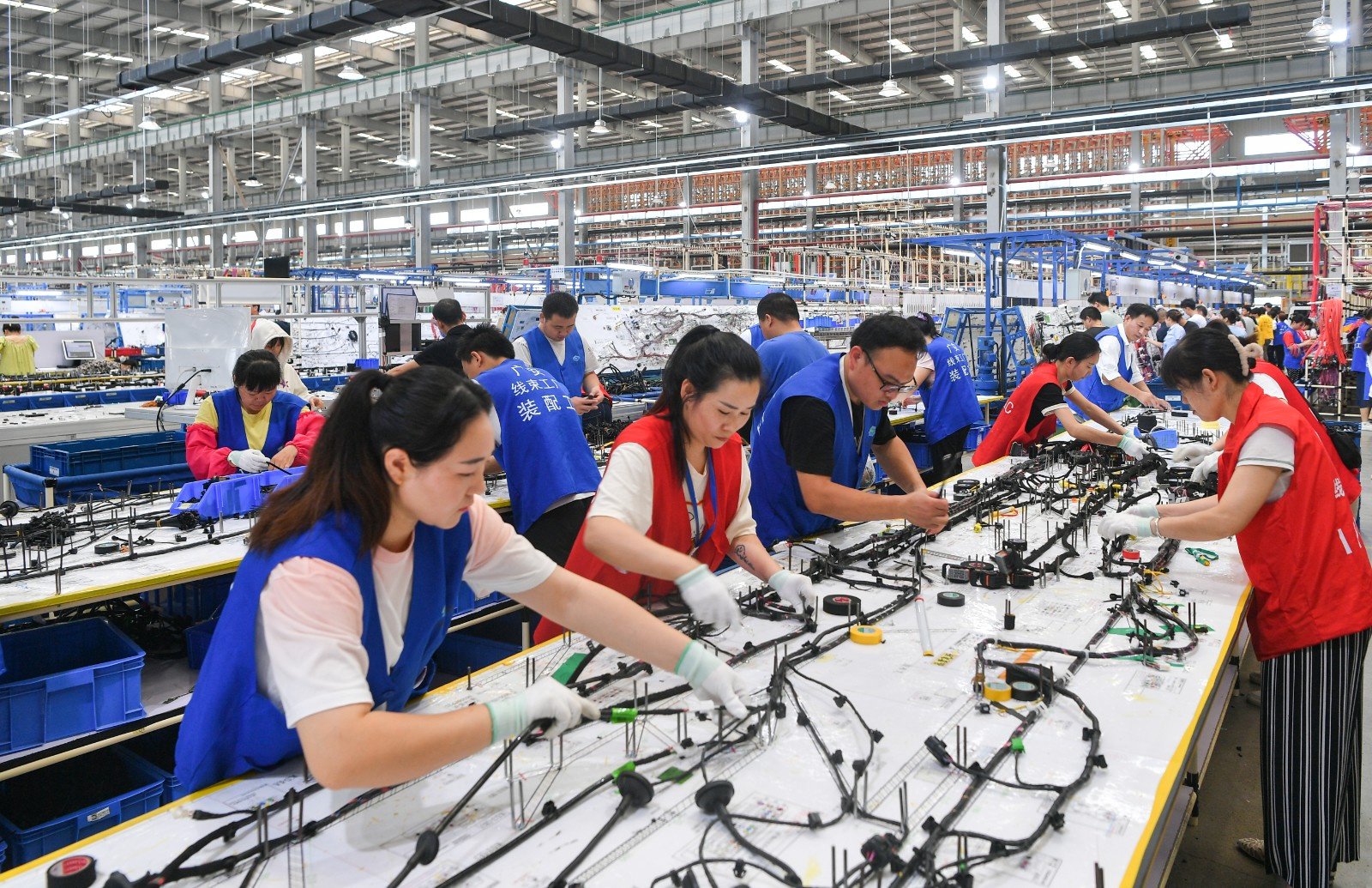 技术开发区一汽车产品制造企业车间内,工人在抢时生产线束订单产品