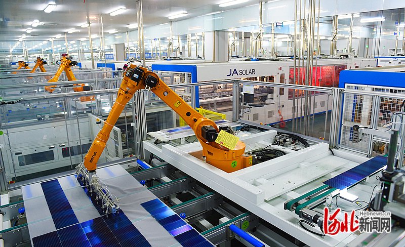 7月13日,晶澳(邢台)太阳能有限公司机械手在光伏组件生产线工作.