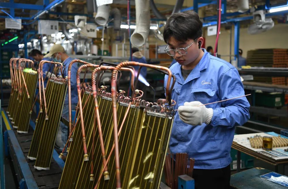 工人在美的家用空调广州工厂的生产线上工作(3月3日摄).