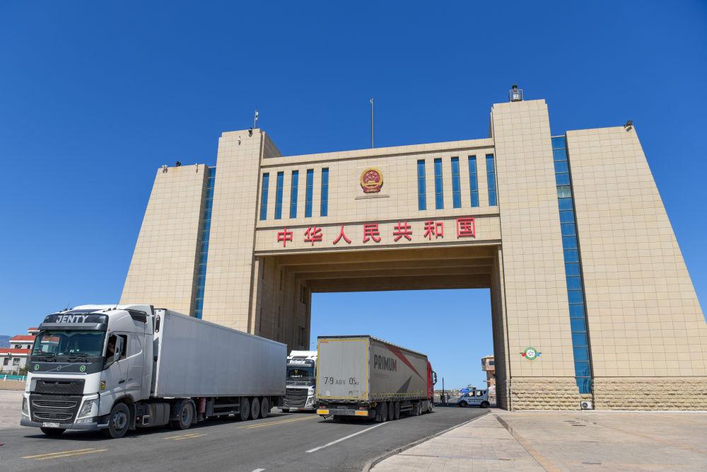 在新疆阿拉山口口岸,几辆货车在进出国门(7月24日摄).