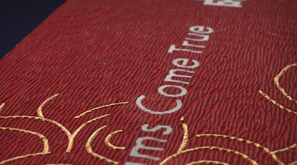 △绶带正反面主色分别为蓝色、红色,融入芙蓉花、太阳神鸟、棋盘格等元素,在自然光线下反射出不同的色彩。