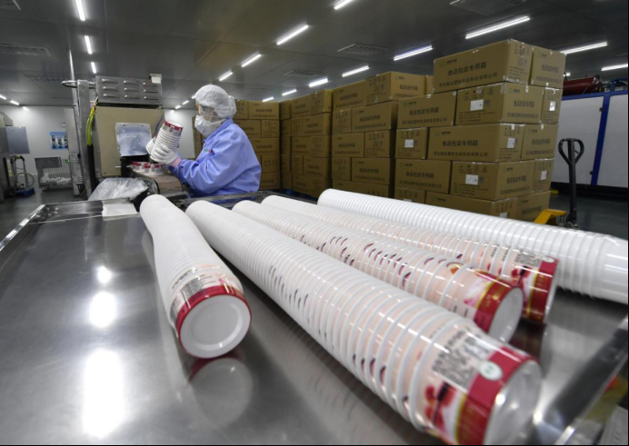 在河北鲲运塑料包装科技有限公司,工人正在酸奶盒包装生产线上忙碌.