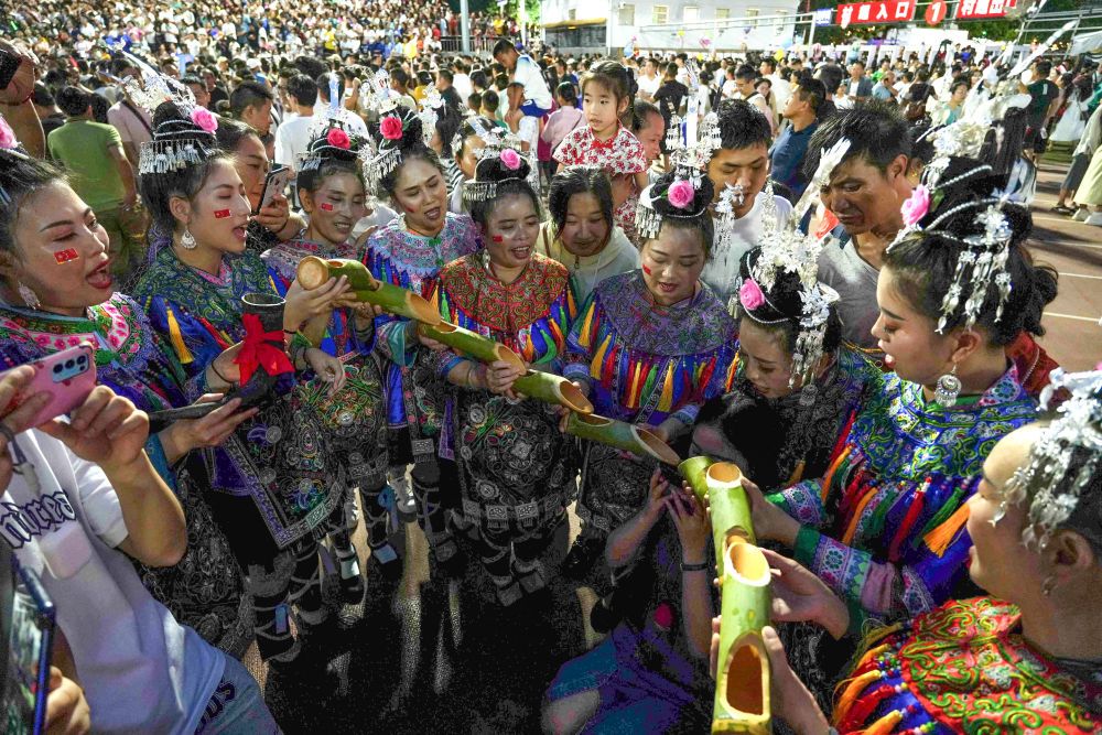 6月23日,游客在体验侗族"高山流水"敬酒风俗.新华社发
