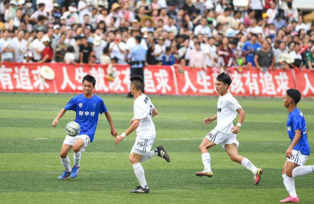 新中村足球队球员(左一)和场坝村足球队球员在"村超"三四名争夺战中