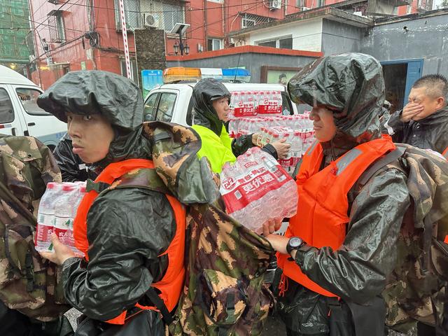 武警战士们正在将矿泉水等物资放入背囊.新京报记者 王巍 摄