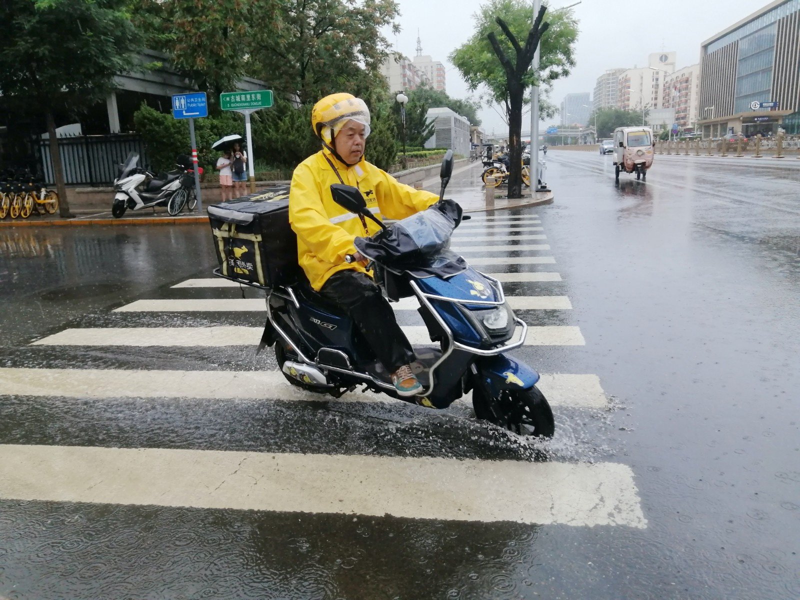 北京石景山区石景山路,外卖小哥在雨中骑行.(图片由cnsphoto提供)