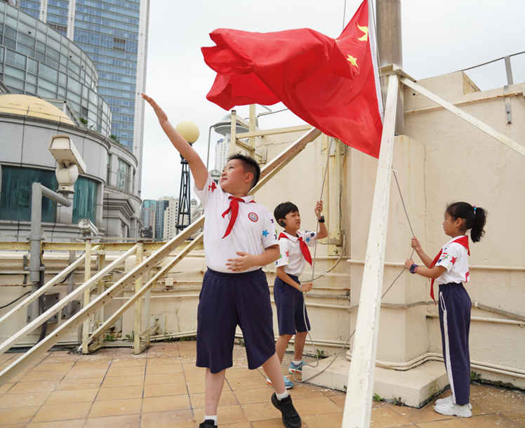 同学们在绮云阁将意义非凡的五星红旗升起。