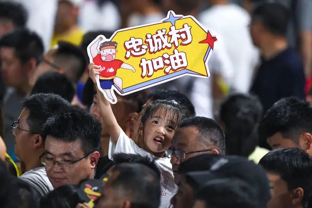 7月29日,一名小朋友在"村超"比赛现场为忠诚村球队加油.