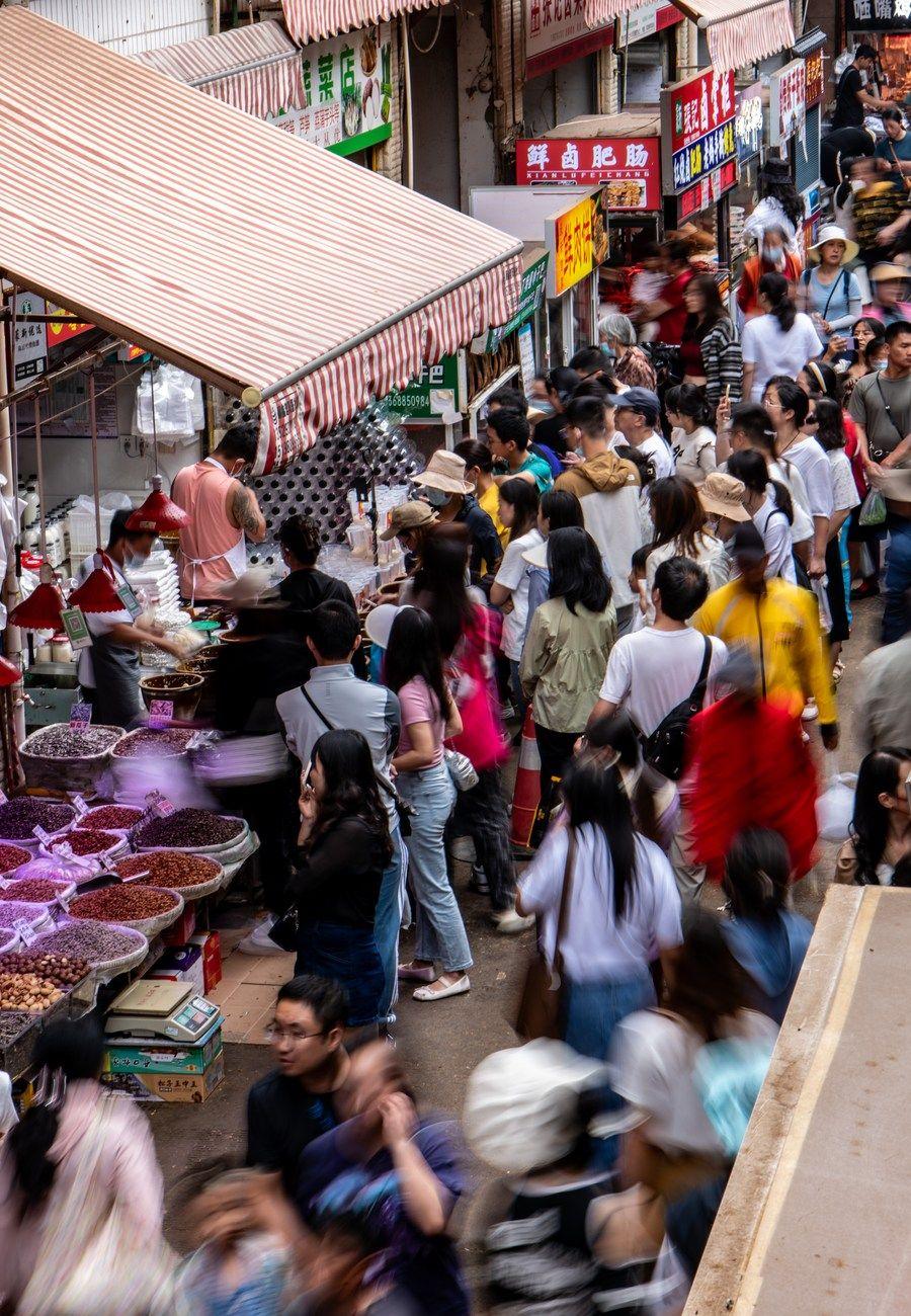 游客在昆明市大观篆新农贸市场排队购买"网红小吃"(7月27日摄).