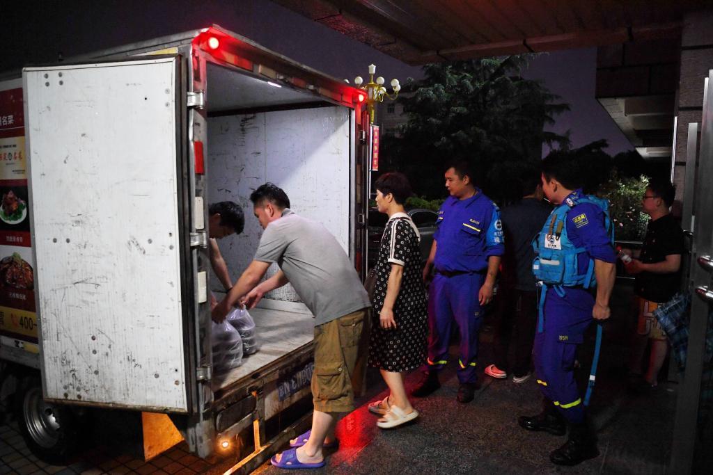 8月1日，河北省涿州市职教中心安置点的工作人员在运送饭菜，准备发放给安置群众。新华社记者 牟宇 摄