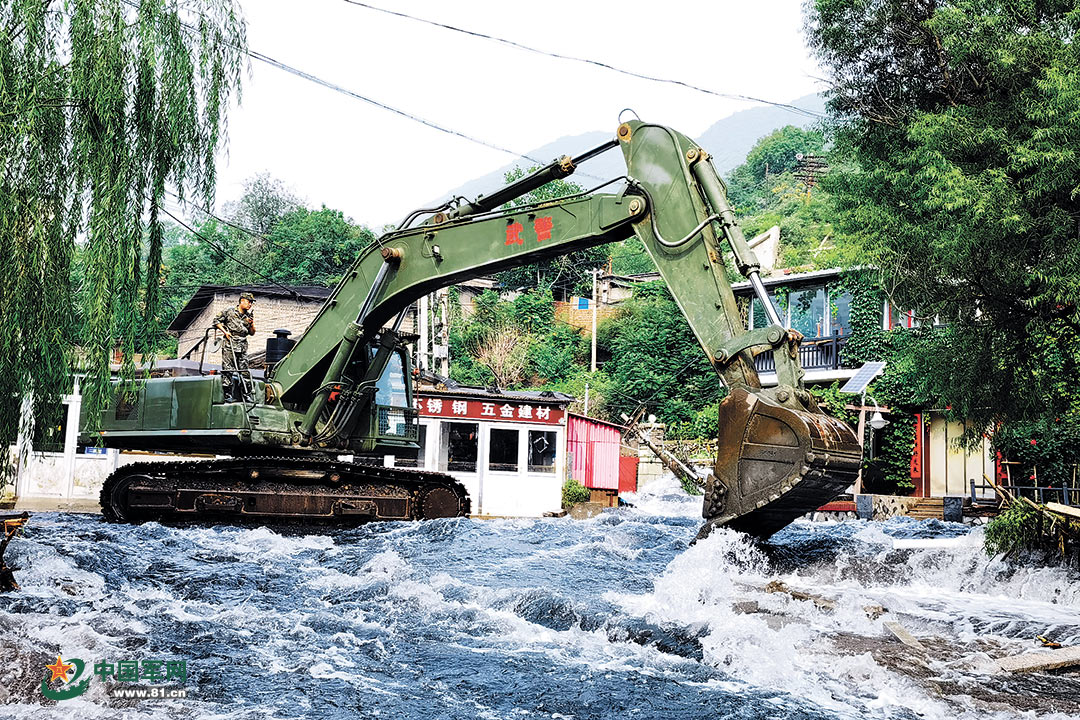 8月3日,武警第一机动总队官兵操作挖掘机在北京市门头沟区王平村拓宽