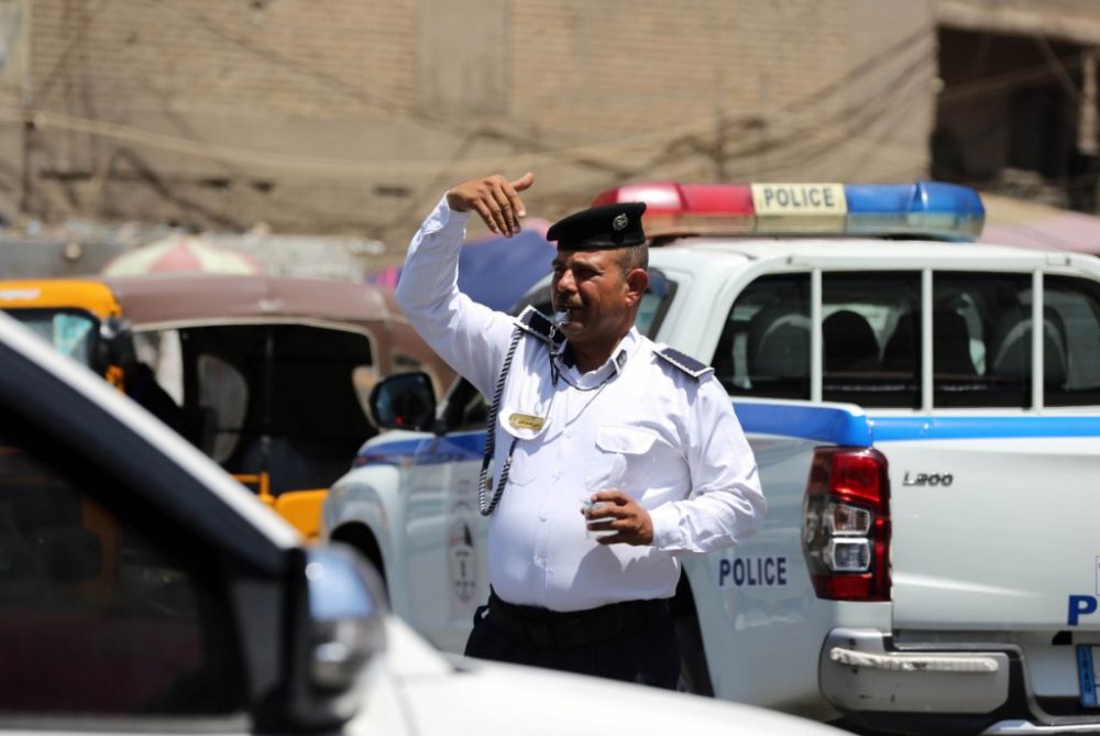 7月18日,在伊拉克巴格达,一名交警在街头指挥交通.