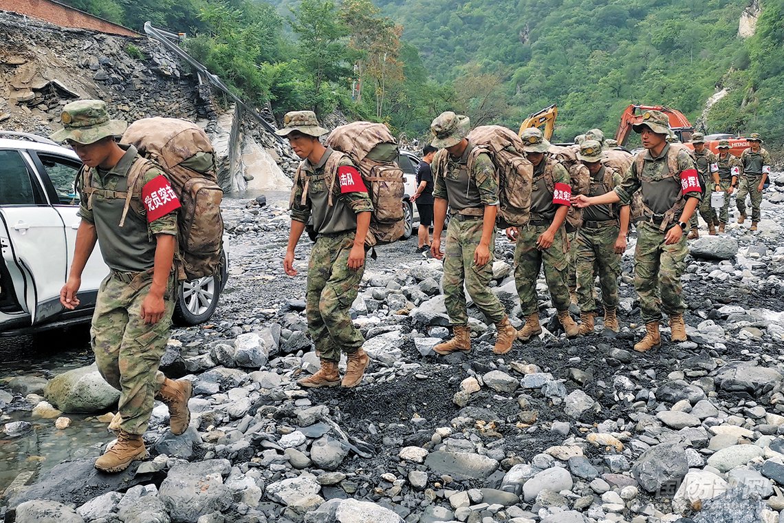官兵徒步前往北京市房山区史家营乡杨林水村,为受灾群众运送救援物资