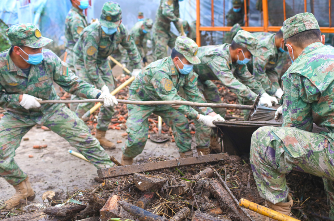 73653部队官兵在洪水退去后,一丝不苟地清理着街道上的垃圾和淤泥.