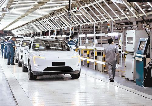 在重庆市长安汽车生产基地车间内,工作人员在新能源汽车阿维塔生产线