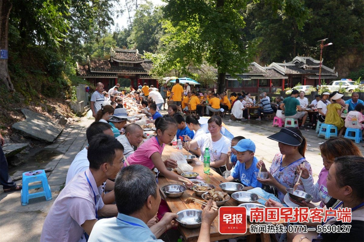 8月10日，在广西龙胜各族自治县乐江镇地灵村，游客们在体验“百家宴”。韦吉阳 黄同凯 摄