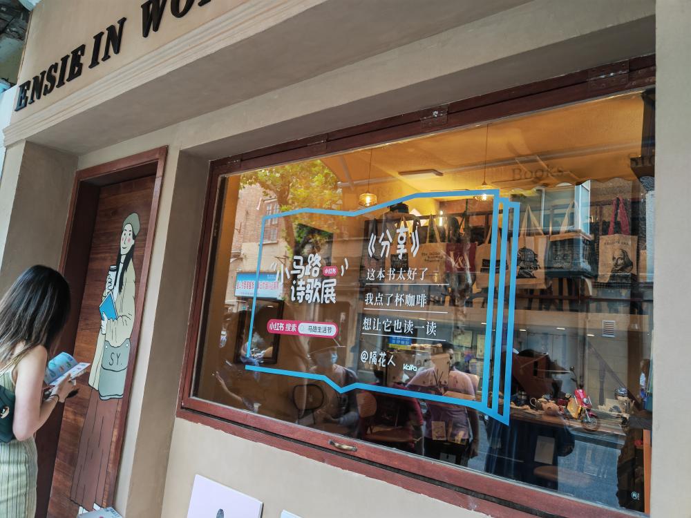 在一家书店门口,透明玻璃窗下放着四个座位,成了街上最热的打卡点之一