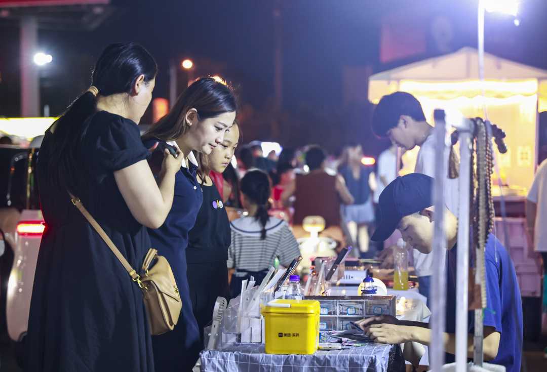 大学生创业专区一处手机贴膜摊位前,顾客排队等候.尹明晓摄