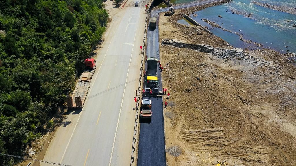 8月20日,在房山区涞宝路,施工队在为抢修出的临时便道路面铺设沥青.