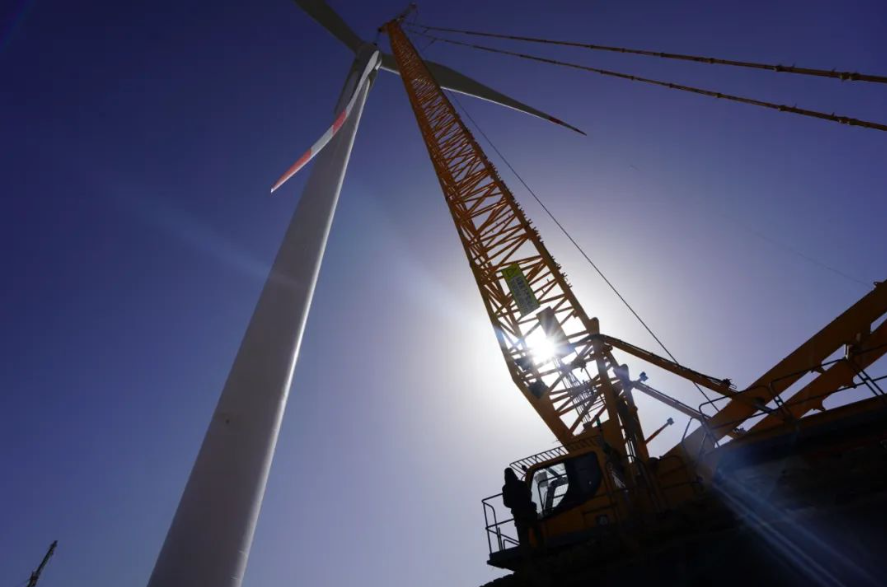 在十三间房百里风区，工作人员对90多米高的5兆瓦风电机组进行调测安装 来源：哈密市融媒体中心