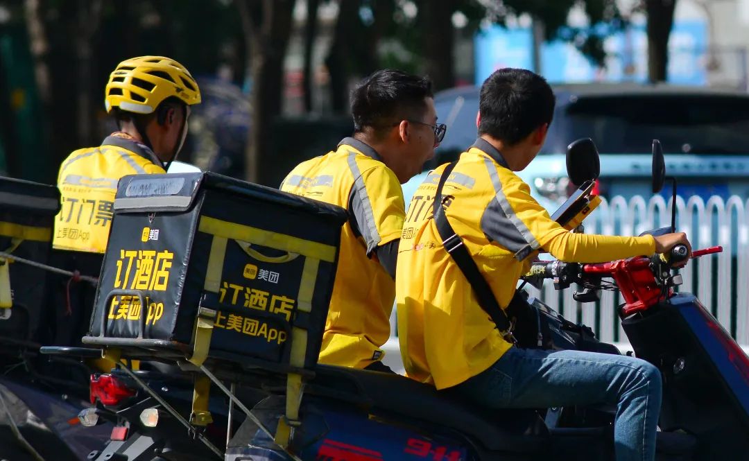 (2023年7月,美团外卖骑手高温下坚守岗位配送餐品.图源/视觉中国)