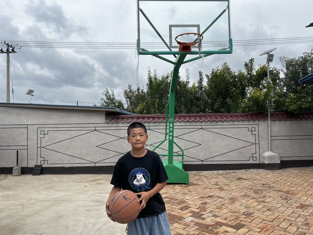 11岁的马家庆在自家院落中打篮球。新华社记者 马思嘉 摄