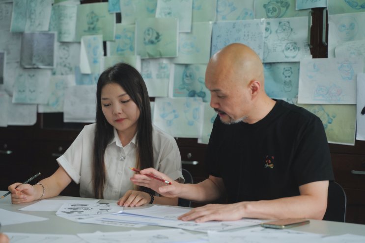 刘平云及学生晏辰洁正在讨论手稿内容