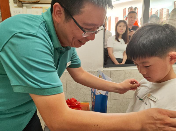 校长为新生佩戴校徽(林则徐小学供图)