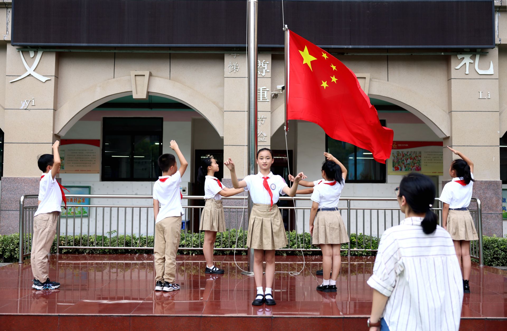 八月三十日,一实校教育集团汇金小学,老师指导学生演练新学期升国旗