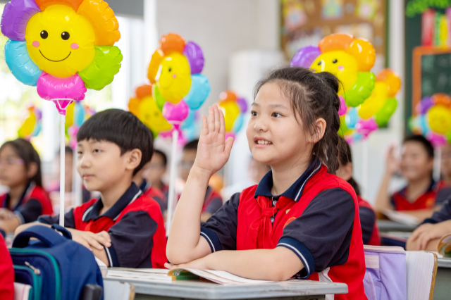 学生们在课堂上举手发言通讯员 谭云俸 摄