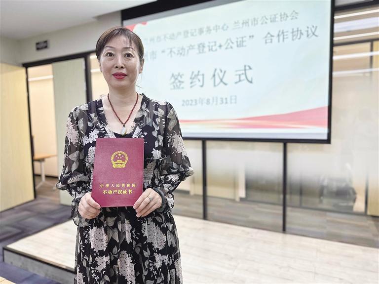 市民朱女士在兰州市公证处领到不动产权证