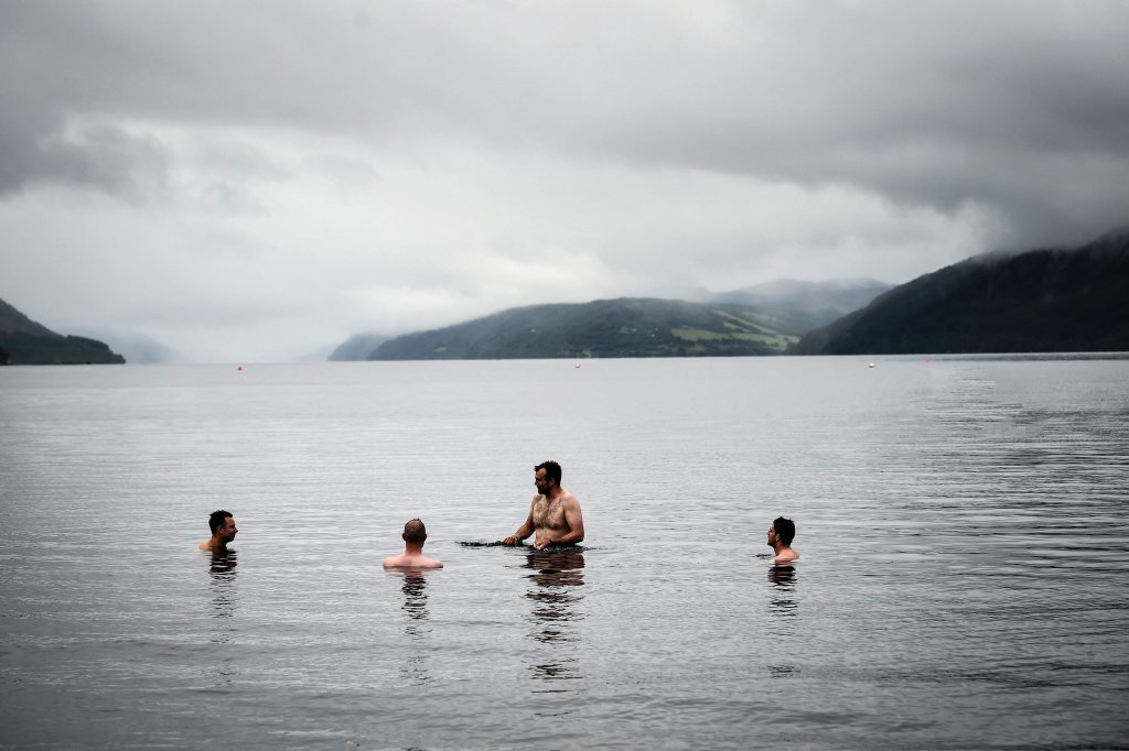 8月27日，在英国苏格兰地区的尼斯湖，人们在湖中游泳。图据新华社/法新
