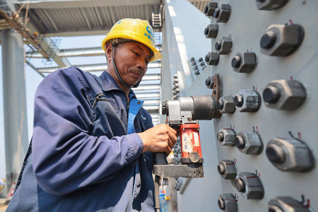 施工人员在加紧桥体的高强螺栓