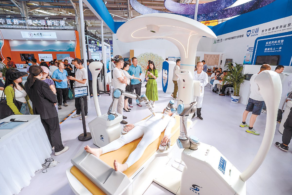 展商在展示一台数字中医循经治疗机器人. 本报记者 武亦彬摄