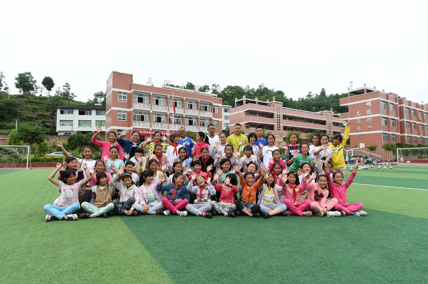 三河小学女子足球队队员与教练在学校操场上合影.