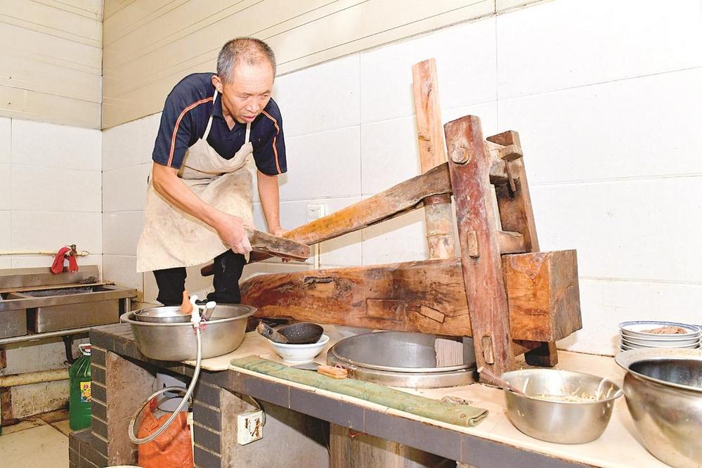 安家饸饹面创始人安书民利用传统的饸饹床制作饸饹面.