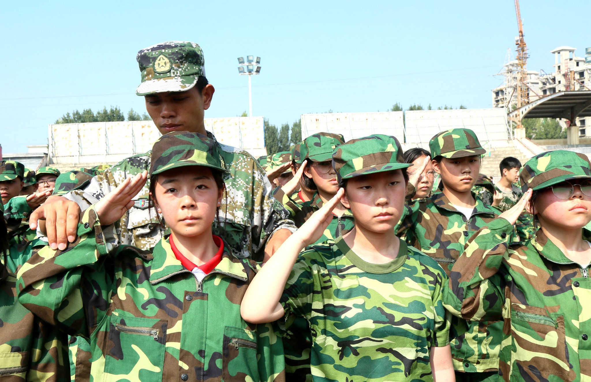 教官给河南省洛阳市汝阳县直属初级中学参加军训的同学整理军装.