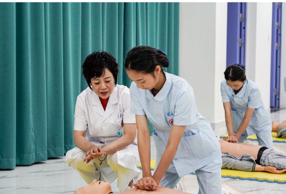 张先庚（左一）在护理实训室指导学生做急救操作。李汶瑾摄