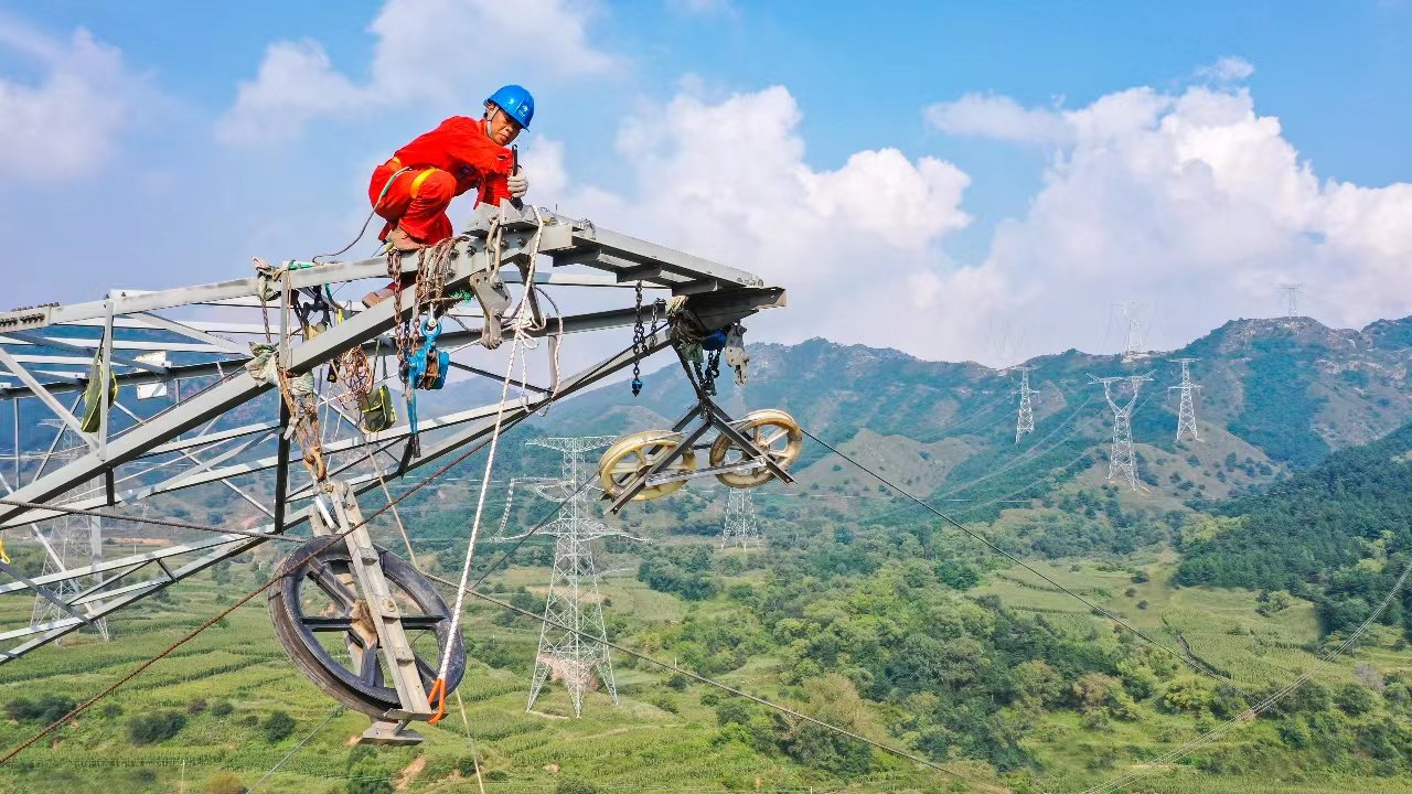 图为国网山西送变电公司员工正在进行高空作业