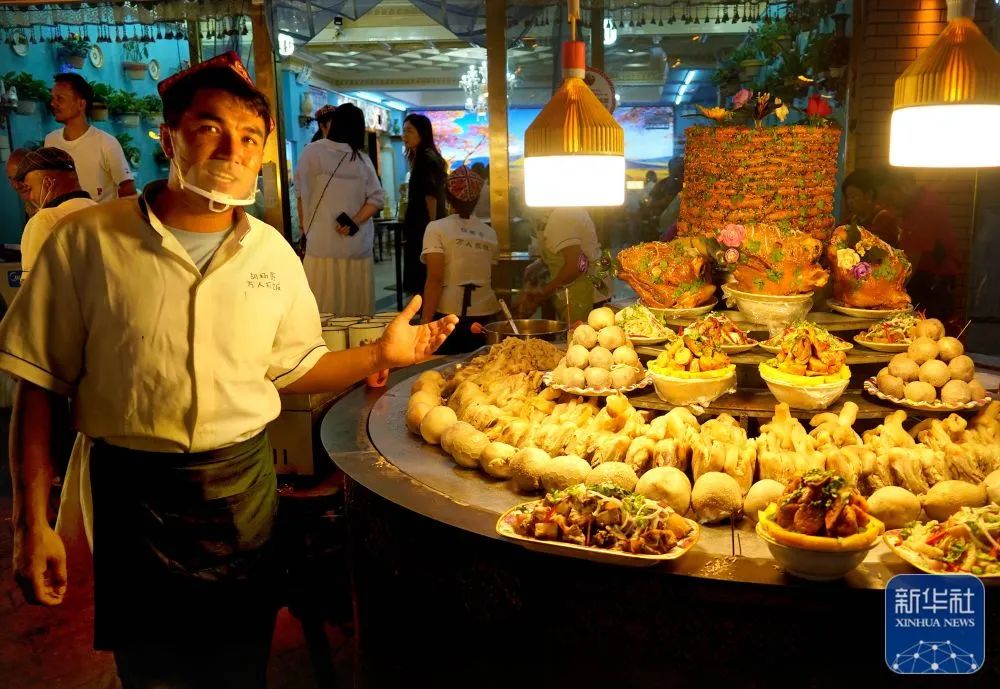 在新疆喀什古城景区内,工作人员在夜市上出售美食(9月4日摄).