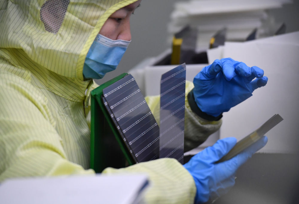陕西西安,检验人员在隆基绿能高陵电池工厂检查电池片.