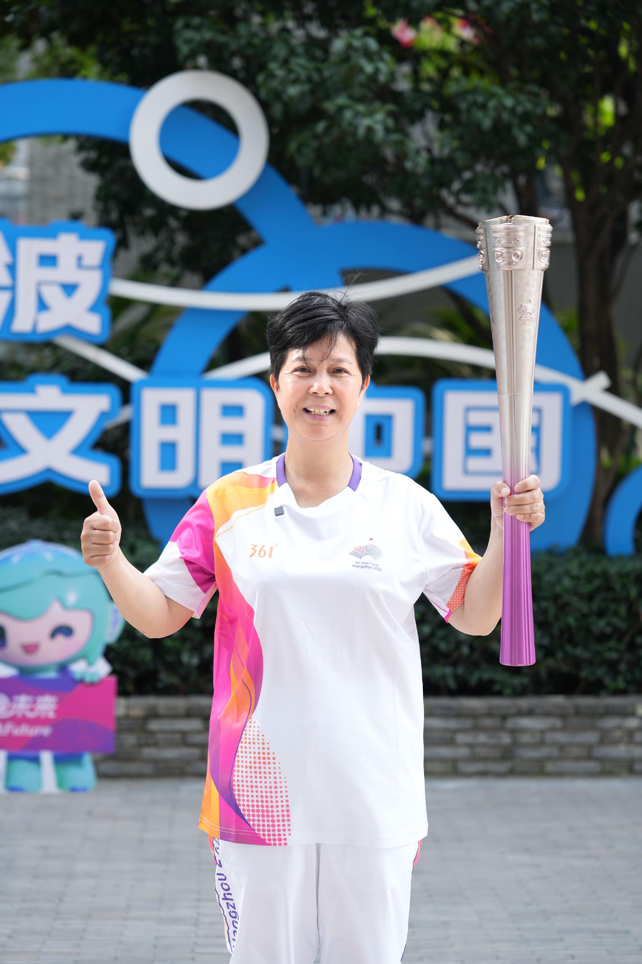 图为林萍手持火炬