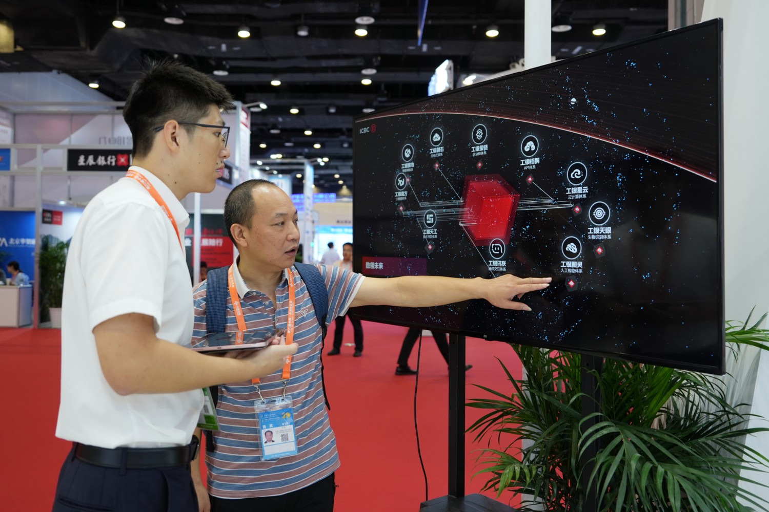 图为工行展台工作人员向观展客户介绍“工行十大技术体系”。（杨元福/摄）